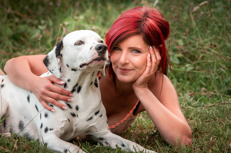 Frau mit Hund im Nebel auf einem Steg