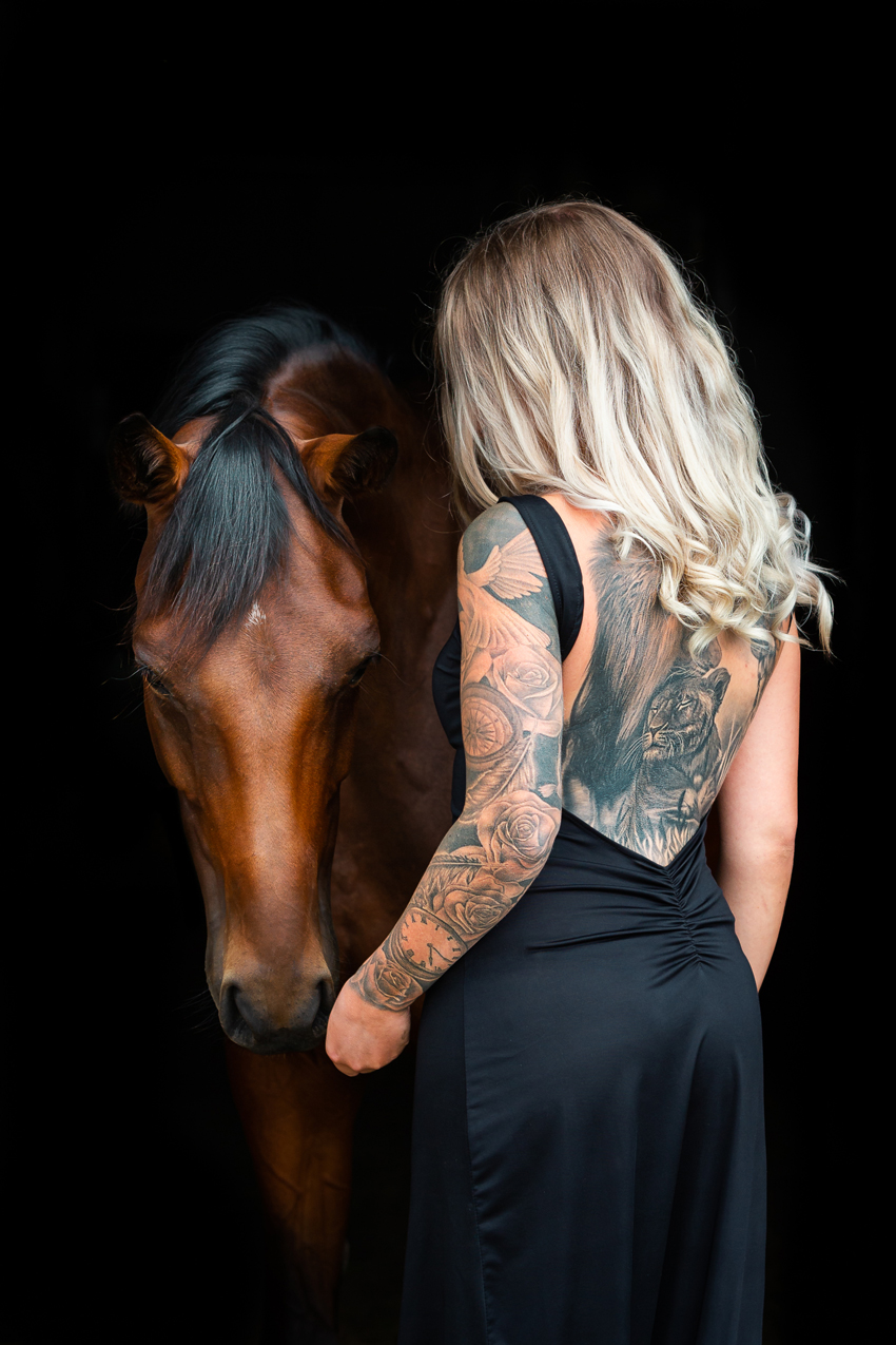 Frau mit Tattoos und Pferd